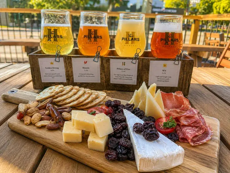 Brewery patio in Bridgeland with a beer flight and charcuterie board on a sunny summer afternoon